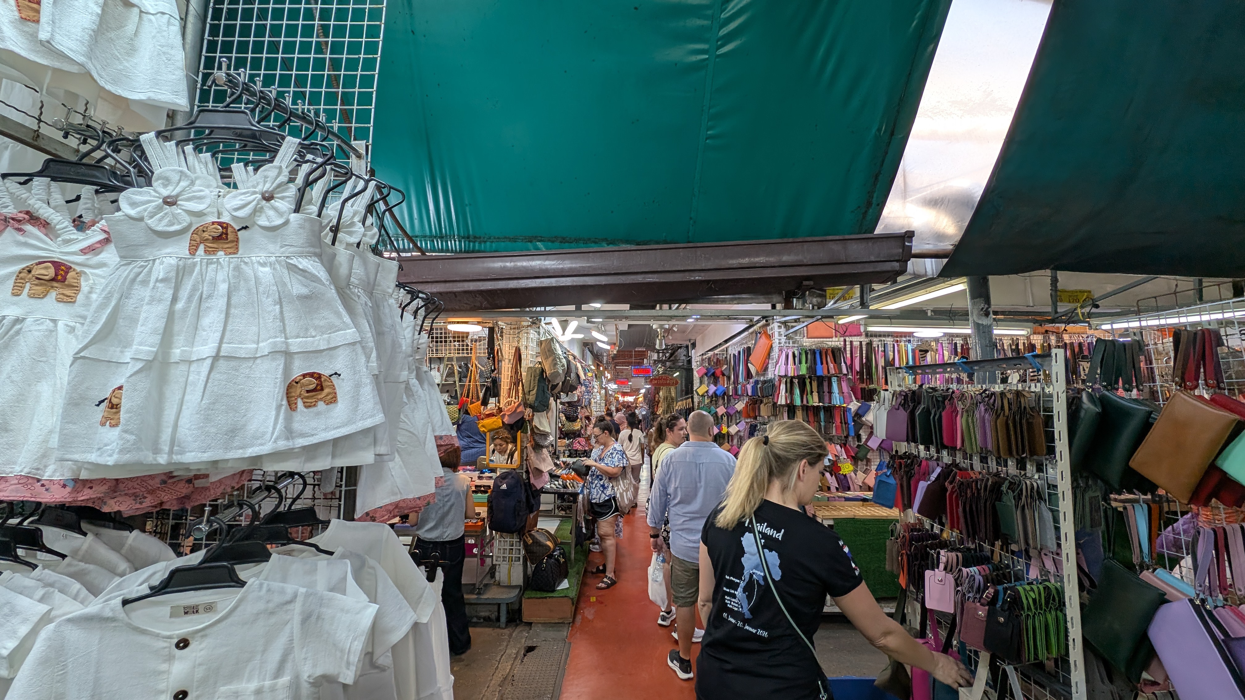 Belebte Marktgasse mit Kleidung und Menschen